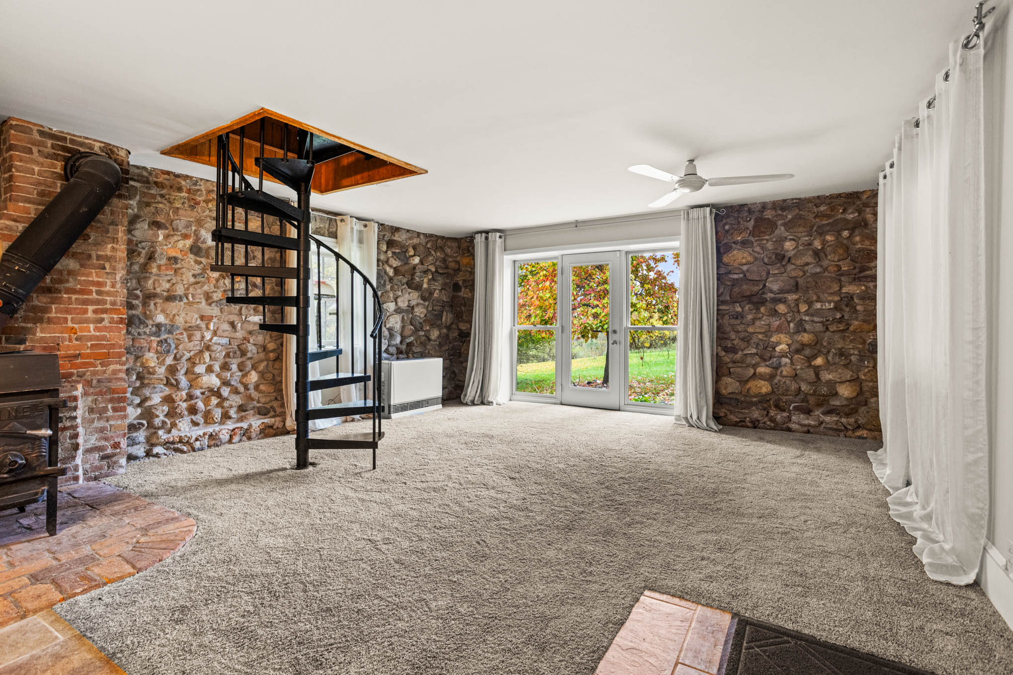 Stone-walled family room with spiral staircase