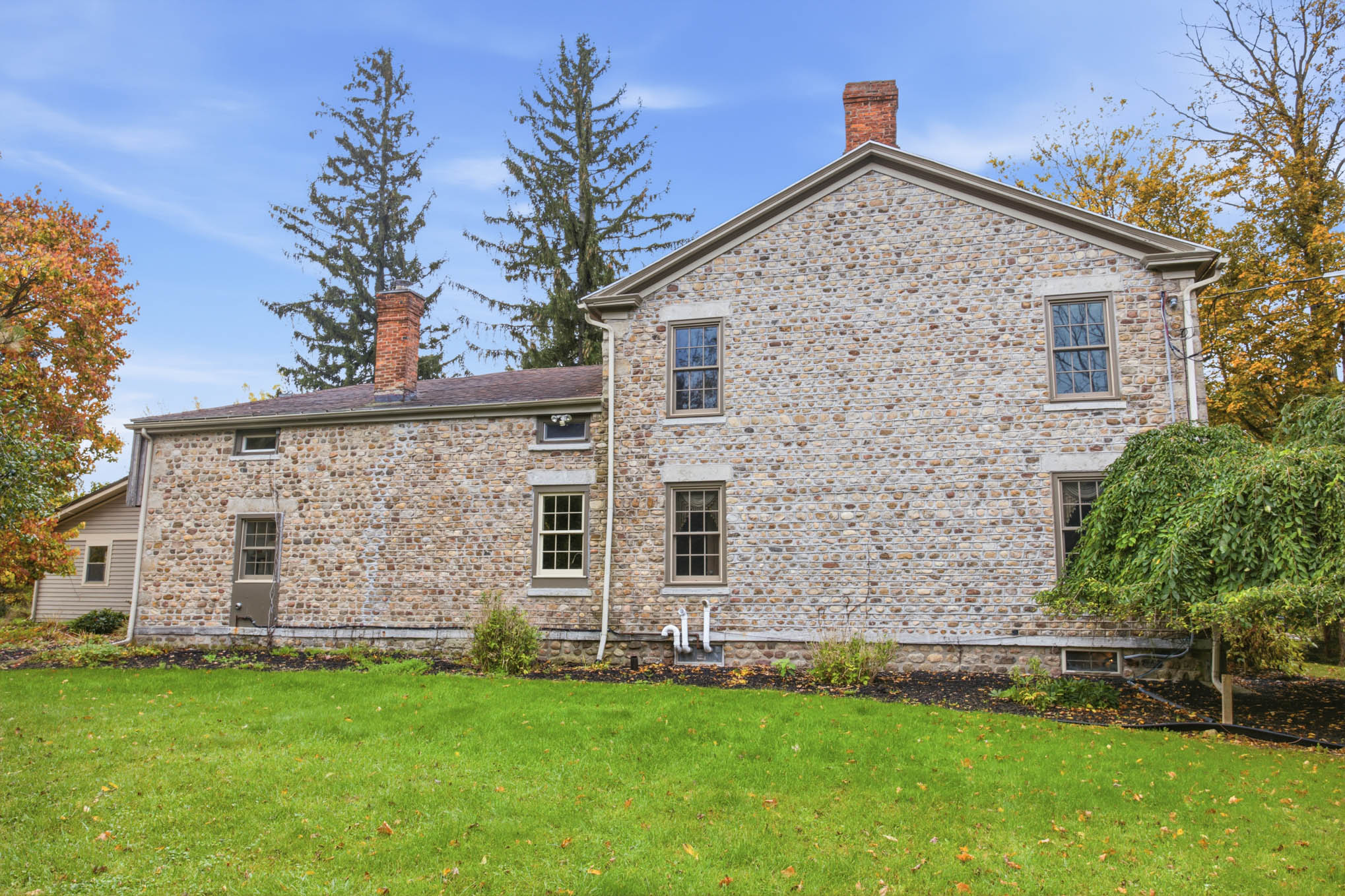 Side elevation of the cobblestone home and lawn