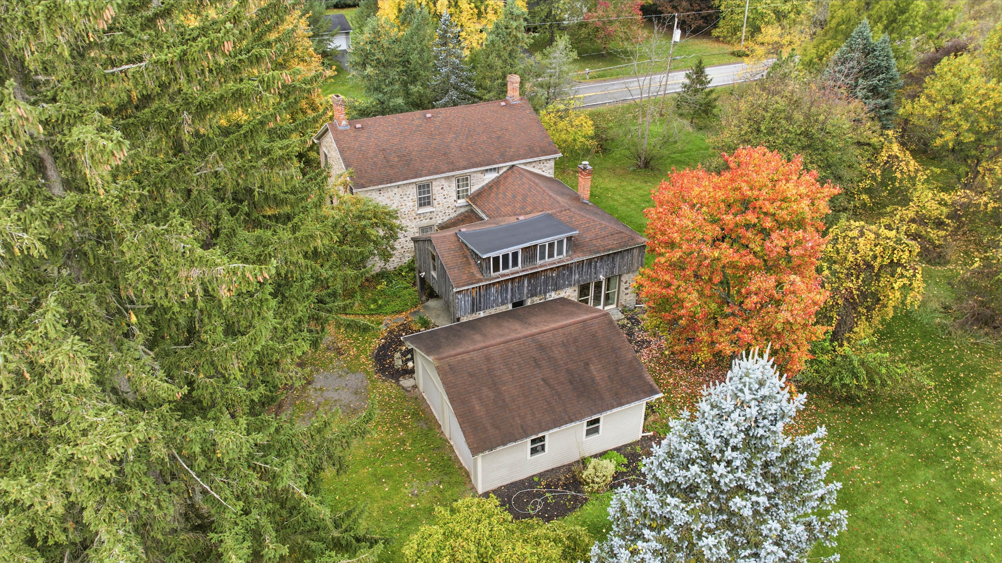 Aerial view of the cobblestone home, rear wing and garage